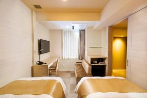 东京Best Western Hotel Fino Tokyo Akasaka的酒店客房设有两张床和电视。