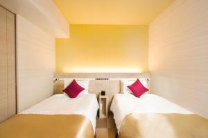 东京Best Western Hotel Fino Tokyo Akasaka的小房间设有两张床,配有红色枕头