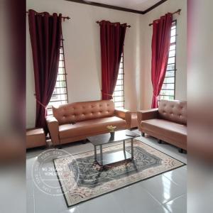 巴佐NQ Jelawat HOMESTAY的客厅配有两张沙发和一张桌子