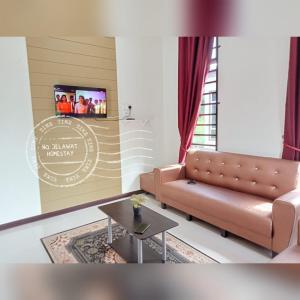 巴佐NQ Jelawat HOMESTAY的带沙发和电视的客厅