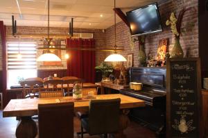 赫龙洛Hotel,cafe,biljart POT的餐厅设有桌子和墙上的电视
