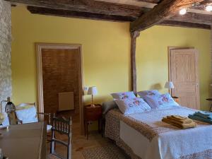 BeaumatDomaine de Galoubet Lot的卧室配有一张床铺,位于一个黄色墙壁的房间