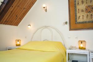 菲亚纳兰楚阿Tsara Guest House的一间卧室配有黄色的床和两张白色的桌子