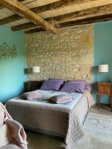 BeaumatDomaine de Galoubet Lot的一间卧室配有一张石墙床