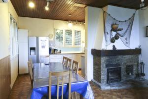 勒·雷约尔·卡纳德尔·苏尔Villa l'Escapade的厨房配有餐桌和壁炉