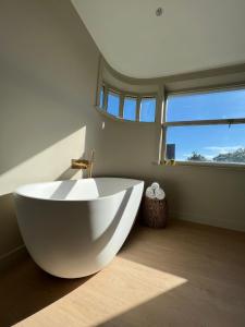 科特赖克Tuss的带窗户的浴室内的白色大浴缸