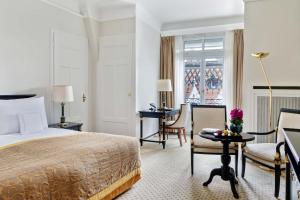 洛桑洛桑宫殿酒店的配有一张床和一张书桌的酒店客房