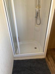 Stevenston367 Caravan的浴室里设有玻璃门淋浴