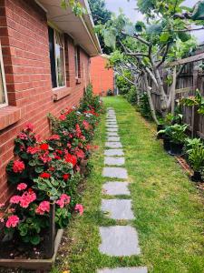 玛莎山Charlie sweet home at Mornington Peninsula的一座花园小径,旁边是一座红花