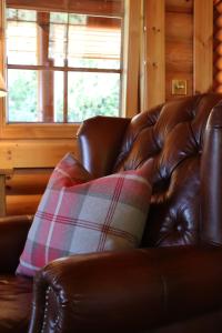特维德上游的贝里克Bunnahahbain - Two Bedroom Luxury Log Cabin with Private Hot Tub的棕色皮沙发,上面有枕头