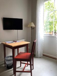 Finnåkers Bruk菲尼克库萨德酒店的客房设有一张桌子、一把椅子和一台电视