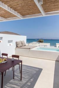 莫罗斯帕罗Citadela Paros Molos - Beachfront Maisonette with Plunge Pool的一个带桌子和游泳池的庭院