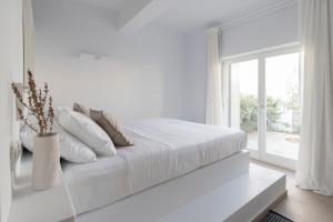 莫罗斯帕罗Citadela Paros Molos - Beachfront Maisonette with Plunge Pool的白色的卧室设有白色的床和窗户。