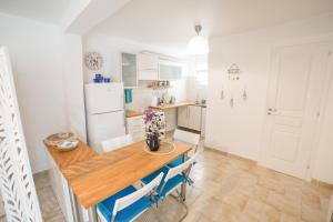 加拉塔斯AGIAZI Poros Summer House的厨房配有木桌和冰箱。