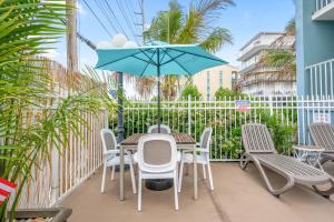 大洋城海岸棕榈树客栈及套房酒店的庭院配有桌椅和遮阳伞。