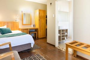 卡图Kathu Gamagara Lodge的一间卧室配有一张床、一张书桌和一面镜子