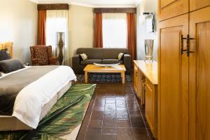 卡图Kathu Gamagara Lodge的一间卧室设有一张床和一间客厅。