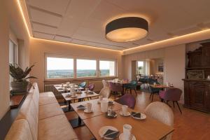 施奈赫普费弗堡酒店的餐厅设有桌椅和大窗户。