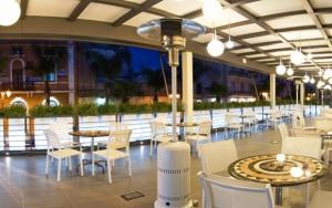 布林迪西维吉尔宫酒店的餐厅配有白色的桌椅和灯光
