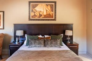 卡图Kathu Gamagara Lodge的一间卧室配有一张带2个床头柜的大床