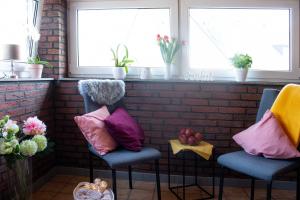 门兴格拉德巴赫门兴格拉德巴赫公寓的带窗户的客房内配有两把椅子和五颜六色的枕头
