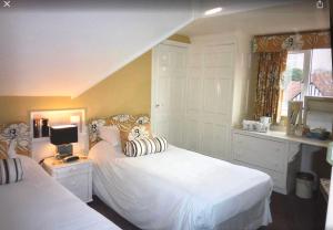 伯恩茅斯Cransley Apart Hotel的一间卧室设有两张白色的床和窗户