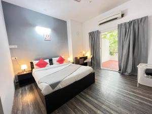 海得拉巴BedChambers Serviced Apartment, Jubilee Hills的一间卧室配有一张带红色枕头的床