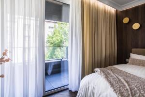 卡托维兹Luksusowy Apartament Przy Filharmonii的一间卧室设有一张床和一个大窗户