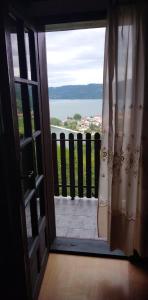 下米拉诺瓦茨B&B Jonovic的通向享有水景的阳台的开放式门