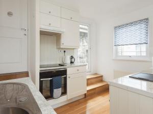 金斯韦尔College View 2 Lower的厨房配有白色橱柜和炉灶烤箱。
