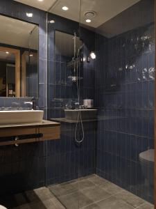 延雪平Quality Hotel Match的蓝色瓷砖浴室设有水槽和淋浴