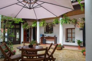圣克里斯托瓦尔-德拉斯卡萨斯Arte Sano Hotel San Cristobal的庭院配有桌椅和遮阳伞。
