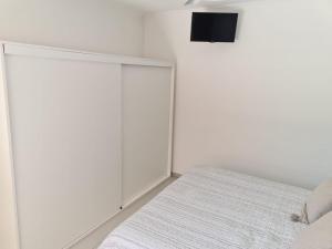 埃斯佩兰萨Apart Esperanza的白色卧室设有一张床和墙上的电视