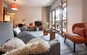 福勒恩Résidence Pierre & Vacances Premium Les Terrasses d'Eos的客厅配有沙发和桌子