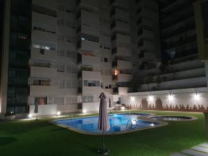 卡拉德费斯特拉特Sunny apartment Benidorm的一座游泳池,在晚上在建筑物前