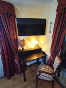 黑林山区圣格奥尔根Hotel Adler的客房设有书桌、电视和椅子。