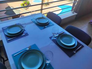 圣地亚哥港Apartamento Balcon de Los Gigantes的一张桌子,上面有蓝色的盘子和酒杯