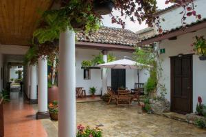 圣克里斯托瓦尔-德拉斯卡萨斯Arte Sano Hotel San Cristobal的一个带桌子和遮阳伞的庭院