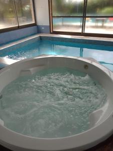 拉库布蕾Hosteria Pastoral & Spa的两个窗户旁的浴缸装满水