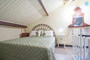 因佩里亚Case Vacanze Borgo Marina IMPERIA的一间卧室配有一张带绿床罩的床