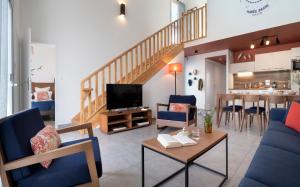 莱萨布勒-多洛讷Pierre & Vacances Premium Les Villas d'Olonne的客厅配有蓝色的家具和楼梯。