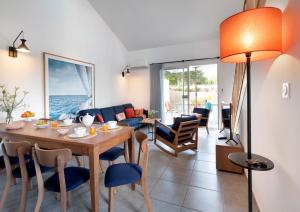 莱萨布勒-多洛讷Pierre & Vacances Premium Les Villas d'Olonne的用餐室以及带桌椅的起居室。