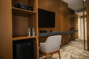 地拉那Urbanin Apartment & Hotel的酒店客房设有椅子和电视。