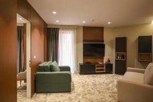 地拉那Urbanin Apartment & Hotel的客厅配有绿色沙发和电视