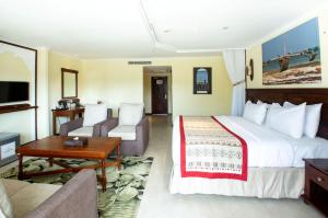 蒙巴萨PrideInn Paradise Beach Resort & Spa Mombasa的酒店客房设有一张大床和一张沙发。