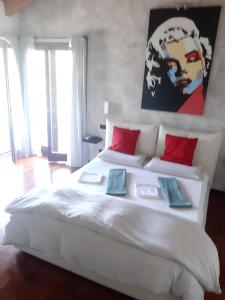 蒙扎Il giardino di Pietro的卧室配有带红色枕头的大型白色床