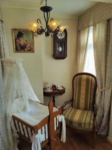 黑林山区圣格奥尔根Hotel Adler的一间卧室配有婴儿床、椅子和时钟