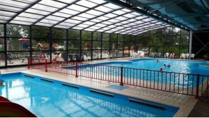 RheezerveenChalet Eben Haëzer的大型游泳池设有大型玻璃墙