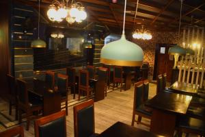 迪卡Ananya Hotel的用餐室配有桌椅和吊灯。