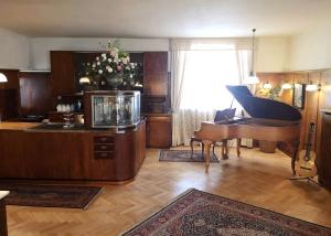 黑林山区圣格奥尔根Hotel Adler的客厅配有三角钢琴和鱼缸